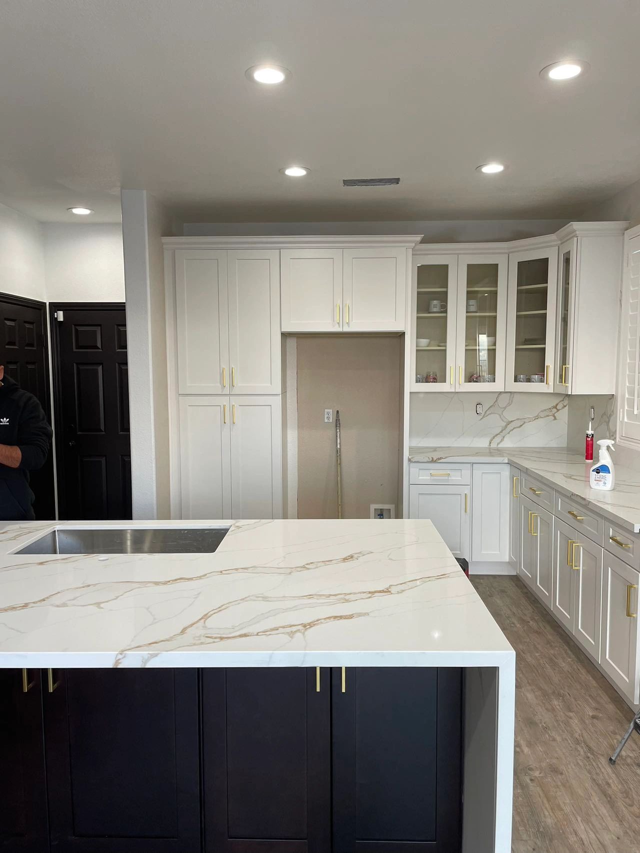 White kitchen with gold hardware and quartz island