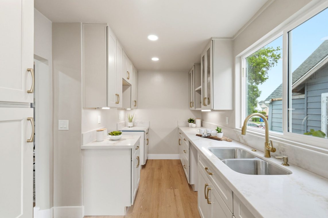 Galley kitchen in Tapue Shaker with brushed-gold hardware and quartz countertops.