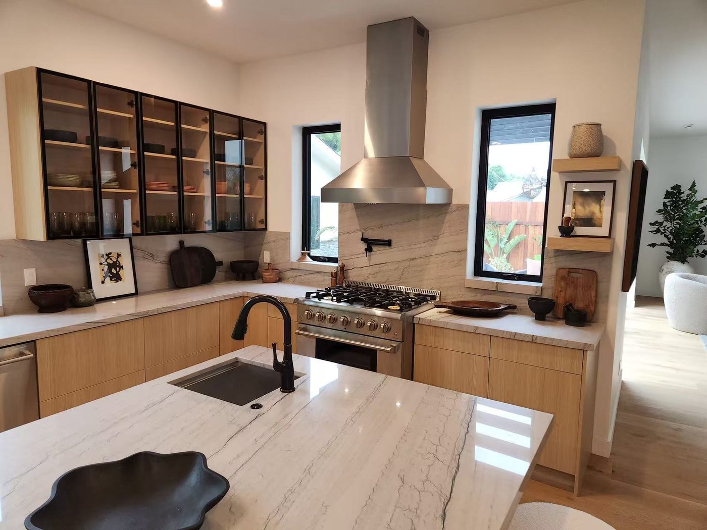 Oak kitchen with a marble island and a stainless pro range.