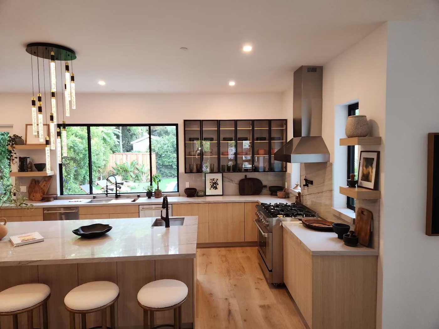 Light kitchen with gold bar pulls and a gas cooktop.