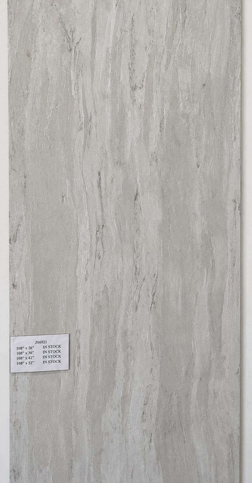 Gray quartz with soft vertical wood-grain veining. — full slab
